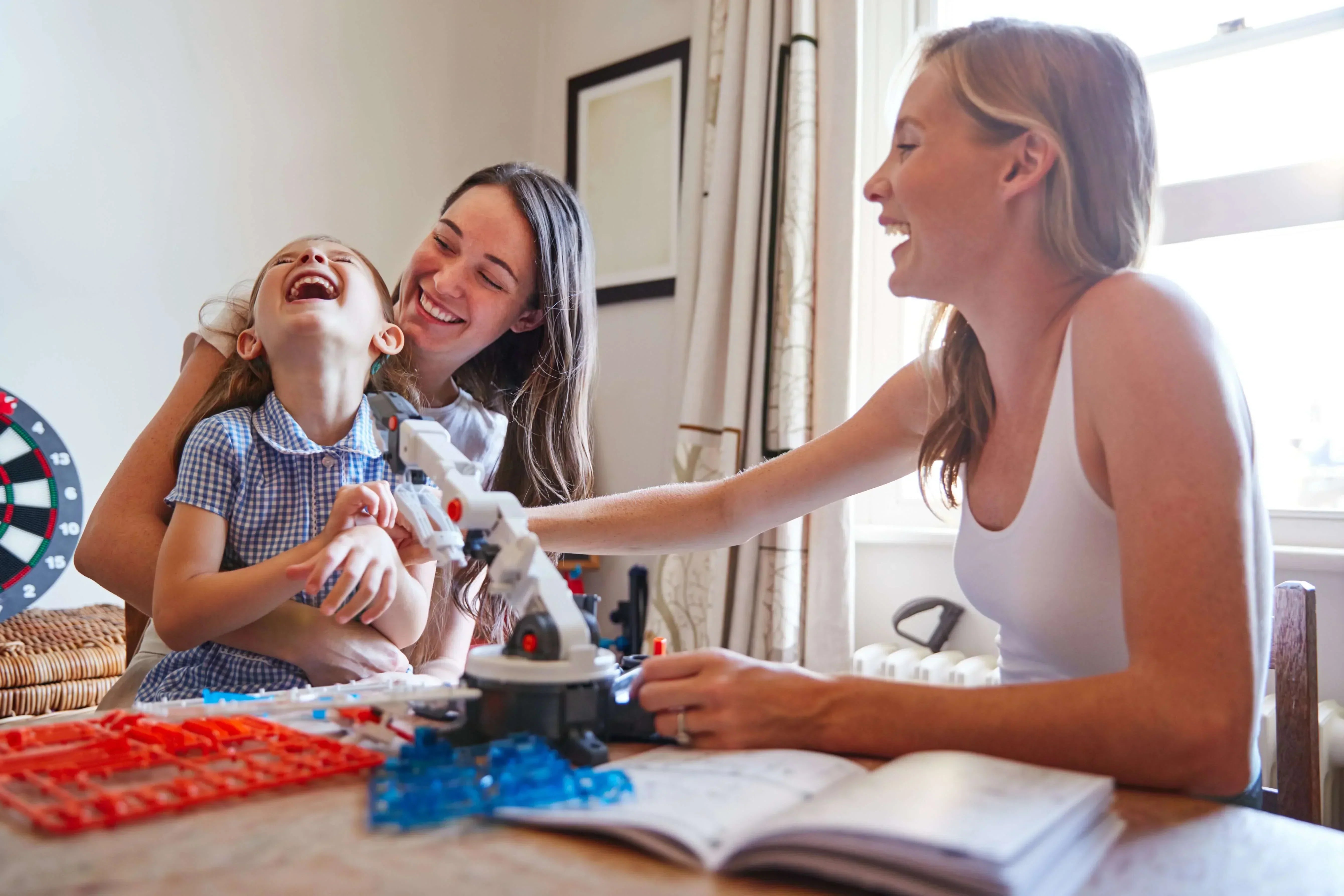 A joyful family moment showcasing a child and two women celebrating happiness while cultivating a grateful mindset through play.