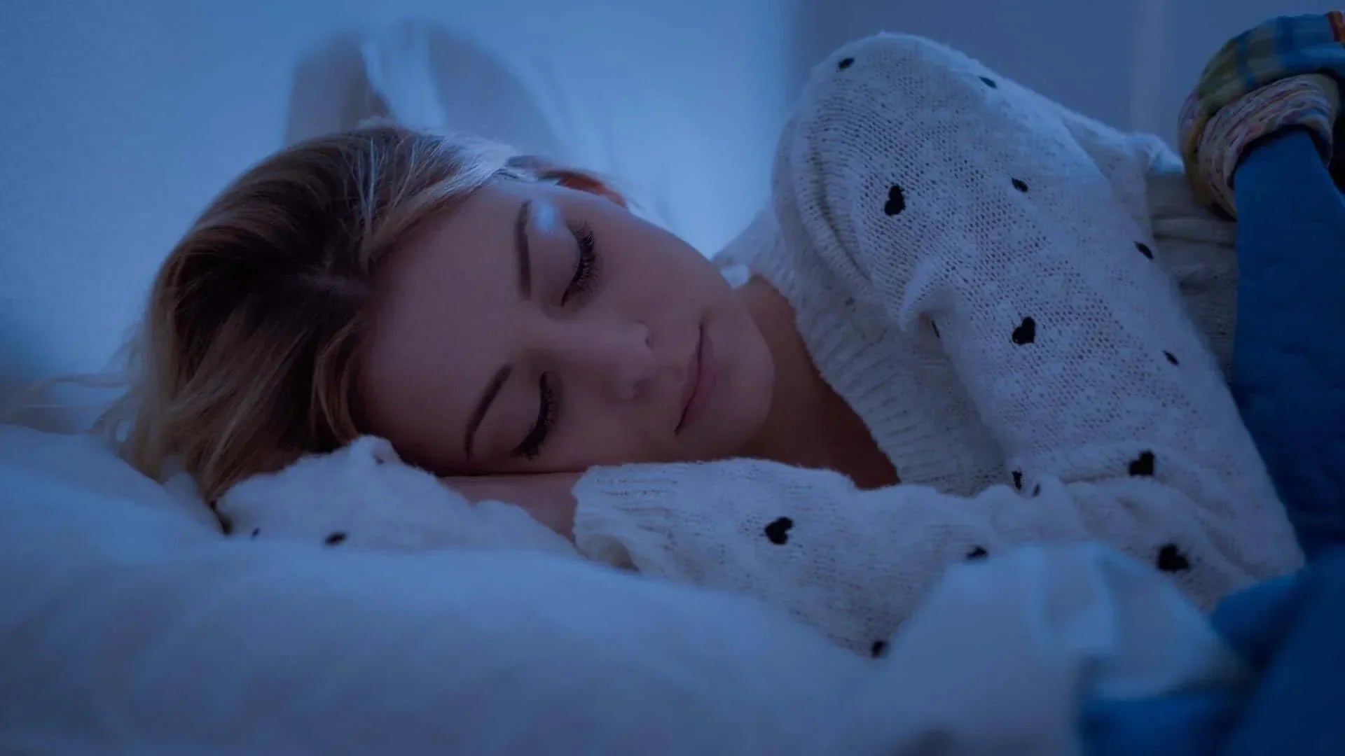 Woman sleeping peacefully in bed, highlighting sleep quality improvement for better rest.