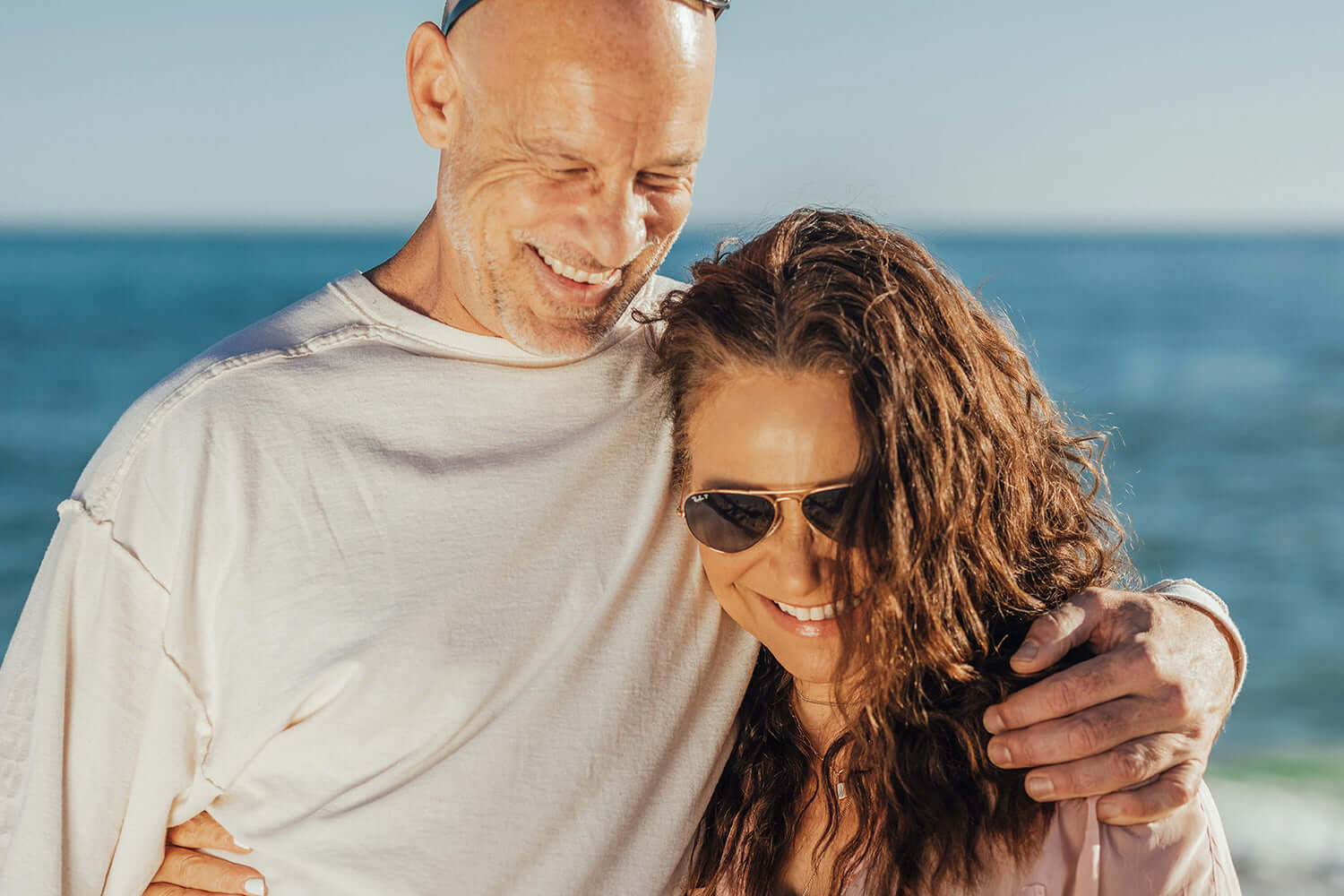 Happy couple enjoying a sunny day at the beach while focusing on ways to improve your mental health fast.