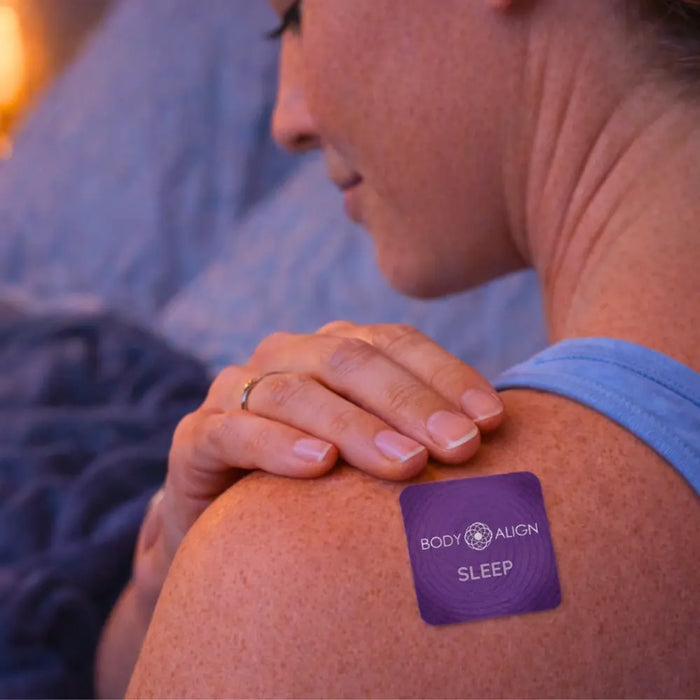 Person with a Body Align Sleep Patch on their shoulder in a bedroom setting